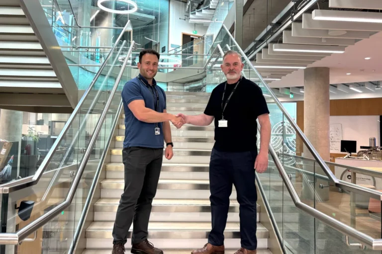 Jack Brennan and Billy McLaughlin shaking hands on a staircase